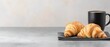© regulator - Two croissants and coffee mug on a gray surface.