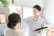 © buritora - 換気扇・レンジフードの説明を受ける主婦の女性と工務店・設備屋・電気工事士・業者の作業着姿の男性