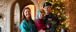 © khan - A heartwarming indoor family portrait near a Christmas tree.