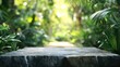 © MUdaylah - Stone table podium floor in outdoor tropical garden, jungle, green leaf plants blur, nature background. Natural product placement base