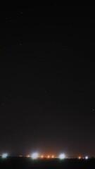 Wall Mural - Night Starry Sky With Glowing Stars Above Landscape With Town City Lights. Night Starry Sky Above Ground.