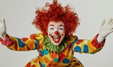 Happy clown with red wig, colorful suit, white gloves.