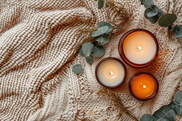Poster - Three burning candles on textured blanket with eucalyptus.