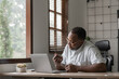 © wichayada - African American man examining credit card at home office, Concept of financial management