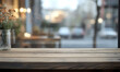 © Mobasser - An empty wooden table with a soft, blurred restaurant interior through a glass window, ideal for showcasing products or creating promotional content