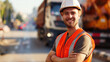 © Qstock - Smiling Construction Worker Wearing Safety Gear on a Busy Street with Trucks in the Background - Daytime Photograph for Industry and Safety Themes