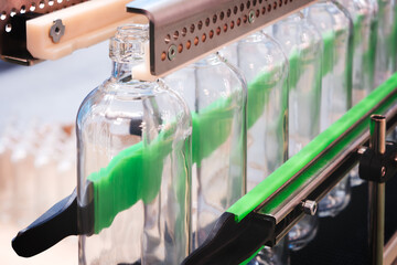 Canvas Print - A line of bottles with a green band on them. The bottles are clear and are being filled