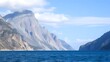 ©  Here Stock Images - Tranquil Blue Fjord Surrounded by Rugged Mountains and Clouds