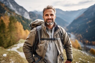 Wall Mural - Portrait of a happy mature man with a backpack in the mountains.