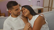 © Krakenimages.com - Hispanic couple embracing on a sofa in their living room with a cozy and loving atmosphere