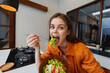© SHOTPRIME STUDIO - Young woman enjoying a fresh salad in a modern kitchen, showcasing healthy eating habits and vibrant colors in a bright, inviting space