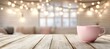 © Andrei - Pink coffee mug on a wooden table with blurred fairy lights bokeh background,cozy home interior