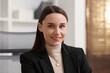 © New Africa - Portrait of businesswoman in jacket at workplace