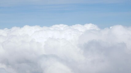 Wall Mural - view from plane over blue sky with white Fluffy clouds while flying through in sunny summer time.nature blue sky cloud and sun for Clean Environment, save energy or transportation holiday concept. 