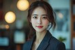 © Jaturong - A woman with long brown hair and a black suit is smiling. Generative AI