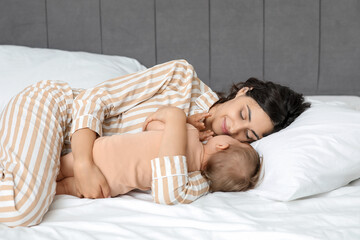 Poster - Happy mother with her little baby lying on bed at home