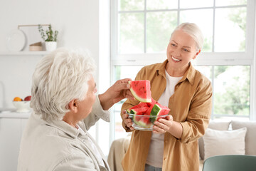 Sticker - Mature couple with slices of fresh watermelon in kitchen