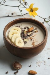 Poster - Smoothie bowl in a wooden bowl with banana and nuts.