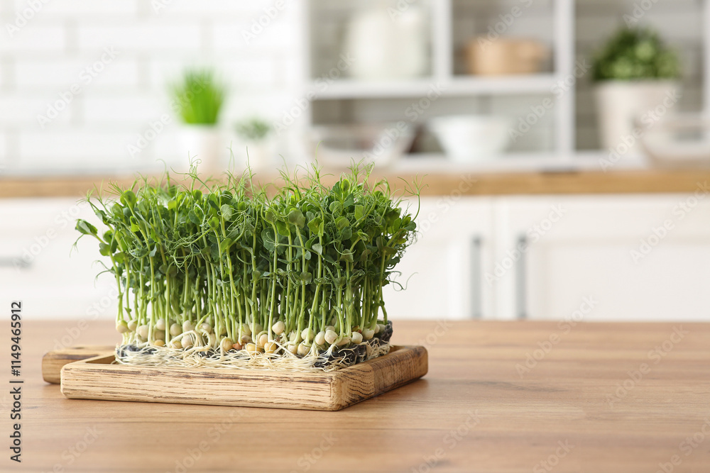 Board with fresh peas micro green on wooden table in kitchen