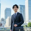 © honami - Young Japanese Businessman in Formal Suit Holding Briefcase in Modern Cityscape