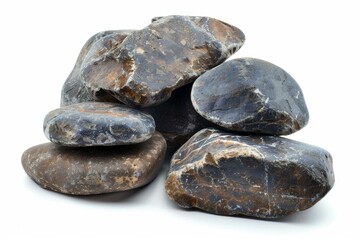Poster - Smooth dark gray and brown stones are piled together on a white background, creating a small rock cairn