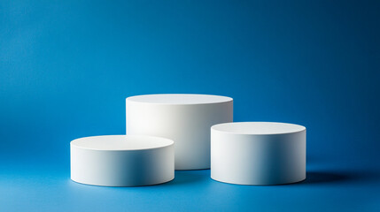 Poster - Simple white cylindrical displays against a vibrant blue background. 