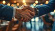© HARRY - Close-up of a businessman's confident handshake during a networking event, emphasizing trust and connection.