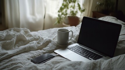 Poster - On a soft bed, a phone rests alongside a laptop and coffee mug, the setup capturing a comfortable, relaxed atmosphere perfect for casual work