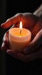 © Hanna - Hands holding a burning candle in the darkness background. Mourning pray. World religion day. Remembrance day. Concept of future telling. Spiritual healing and energy of soul. Copy space. Vertical