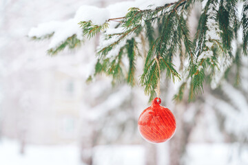 Wall Mural - Red glasses bauble on christmas tree with snow outdoor.