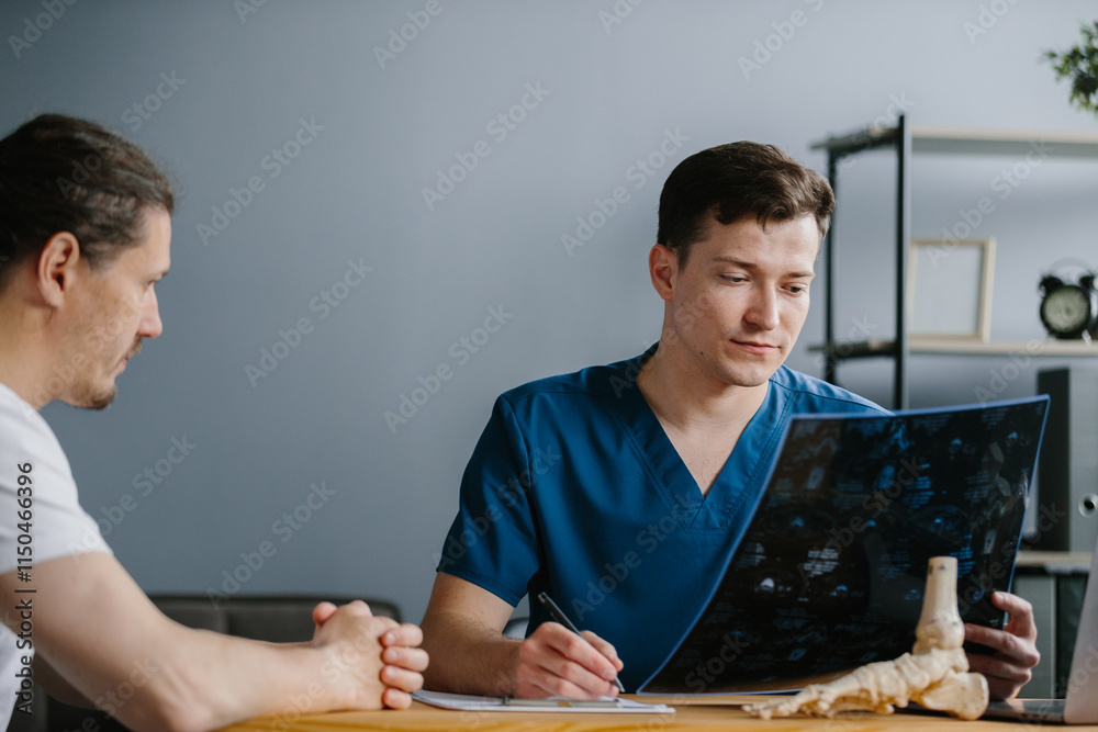 Physician presenting an X-ray to a patient while explaining the results ...
