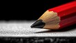 © arsyi_06 - Close-up of a sharpened red pencil on a textured surface.