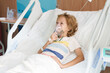 © famveldman - Sick child in hospital room. Kid in clinic ward.