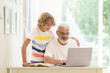 © famveldman - Senior man working on computer with grandchild
