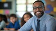 © Mechastock - Candid school class portrait of a black male teacher in a classroom with copyspace