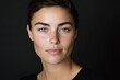 © c80 - Portrait of a confident woman with striking features and deep green eyes against a dark background