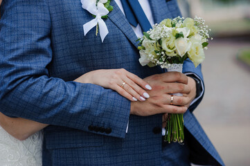 Wall Mural - Elegant Wedding Couple Embracing with Flowers and Rings