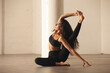 © Mark Adams - Young athletic woman doing compass yoga pose in urban loft space