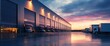 © EFA - A warehouse loading dock at sunset, featuring parked delivery trucks.
