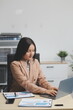 © Kansuda - Asian Businesswoman Using laptop computer and working at office with calculator document on desk, doing planning analyzing the financial report, business plan investment, finance analysis concept.