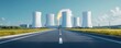© Adul khotchasri - A serene view of a nuclear power plant with cooling towers alongside a clear road, surrounded by green fields and a bright blue sky.