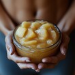 © KADER - Hands holding a jar of applesauce with a fitness motivation label.