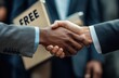 © hakule - Two men shaking hands with a box that says free