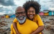 © hakule - A man and woman are smiling and posing for a picture on a beach