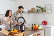 © Pixel-Shot - Young couple with multi cooker preparing food in kitchen