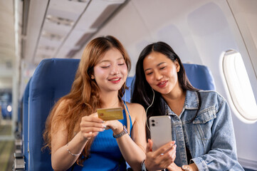 Wall Mural - Women enjoy a conversation about the convenience of a credit card lifestyle during the flight.