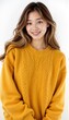 © InspirationDesign - Smiling Asian woman in yellow cable knit sweater against white background
