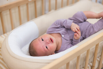 Wall Mural - Baby sleeping in crib and looking up