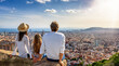 © moofushi - A tourist family enjoys the panoramic view of the skyline of Barcelona, Spain, during their city trip vacation