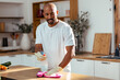 © nenetus - Attractive handsome man cleaning kitchen at home